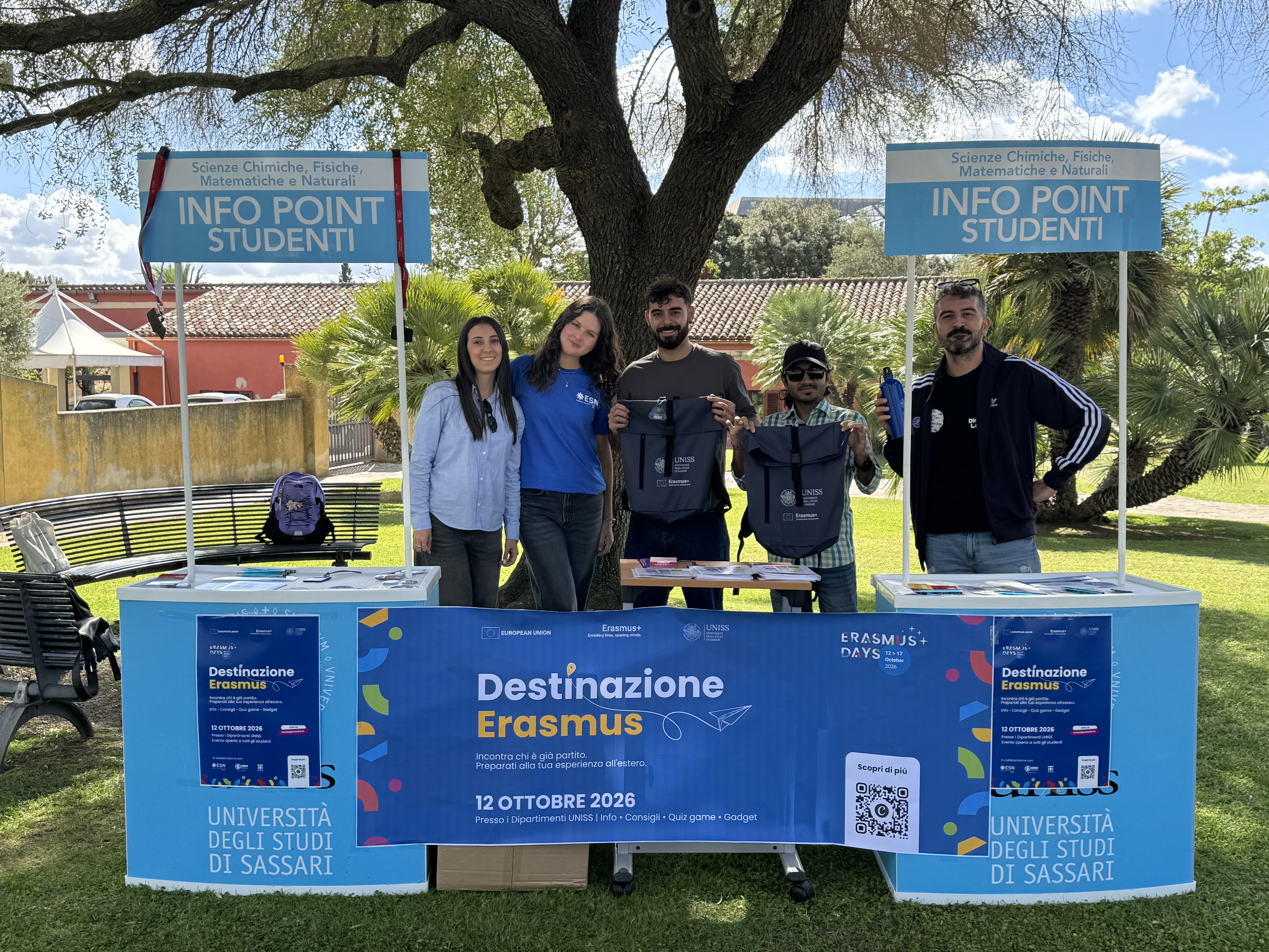 Cinque partecipanti posano dietro il banner di Destinazione Erasmus, tra i due info point dedicati agli studenti.