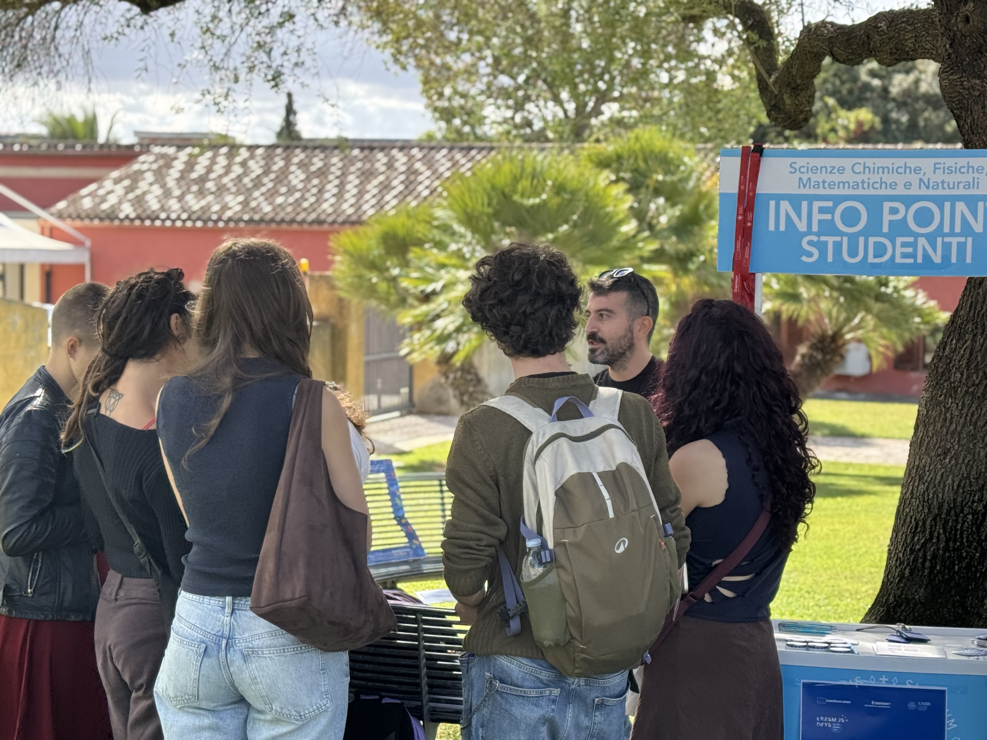 Studentesse e studenti, ripresi di spalle, ascoltano il referente Erasmus durante un momento informativo di Destinazione Erasmus.