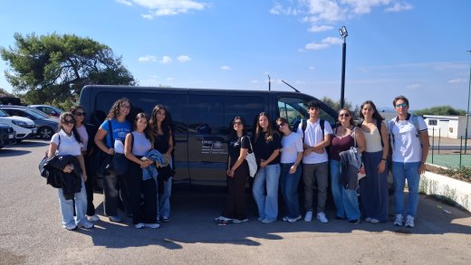 Foto di gruppo delle studentesse e degli studenti di VetSassari accanto al pulmino del Dipartimento di Medicina Veterinaria, in occasione dell’Expo internazionale canina.